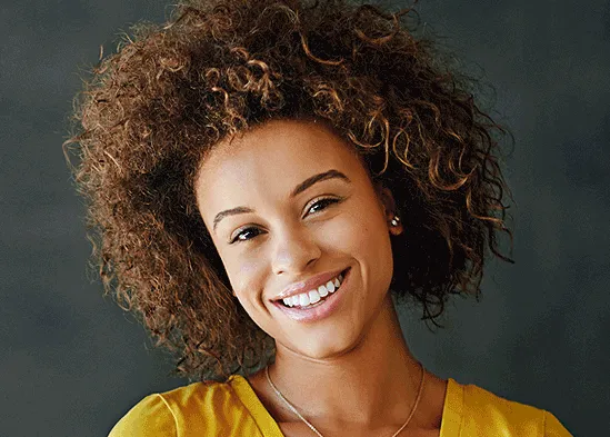 Portrait of a smiling young woman with curly brown hair